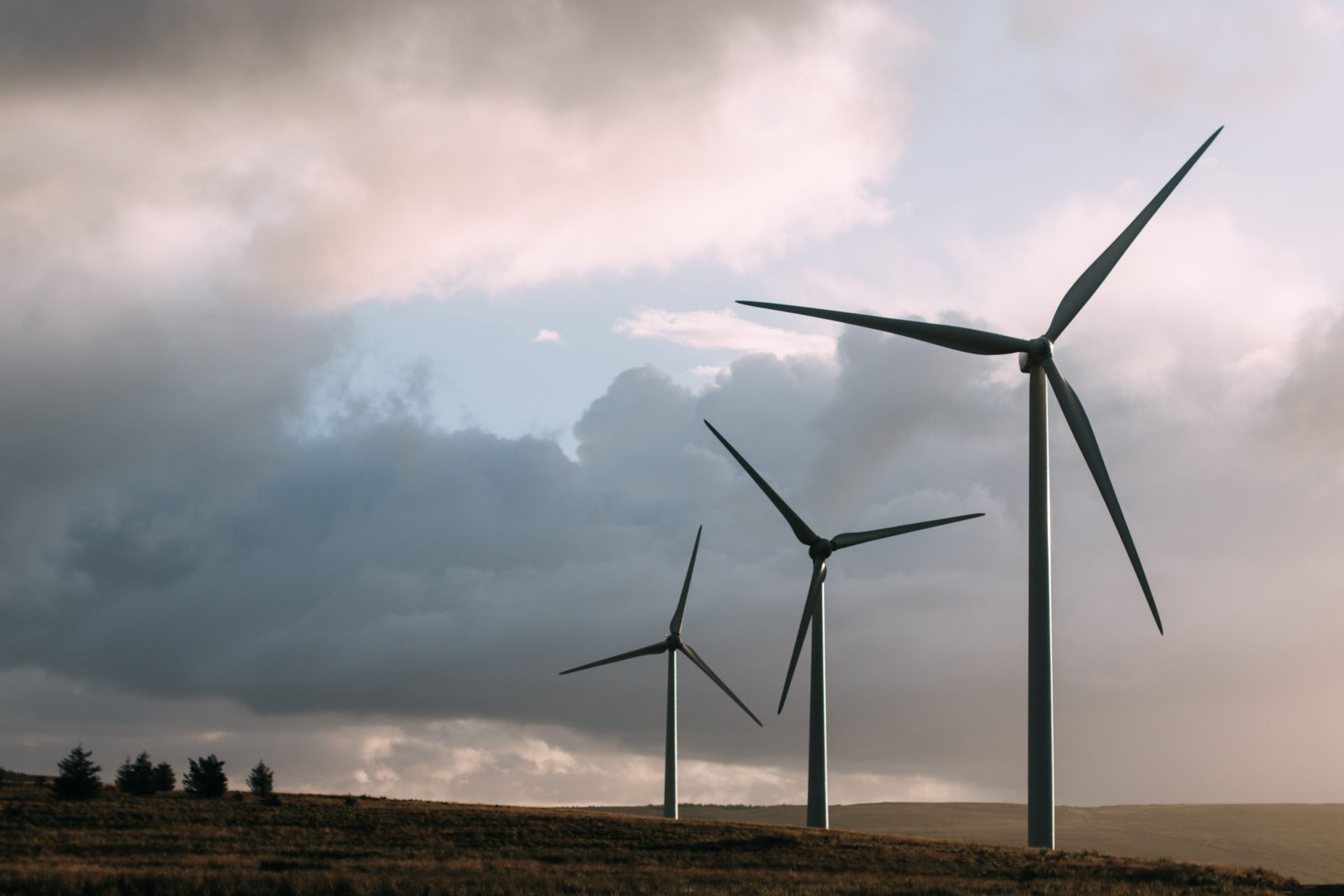 Windkraftanlagen, die erneuerbare Energie erzeugen, unter einem dramatischen, bewölkten Himmel.