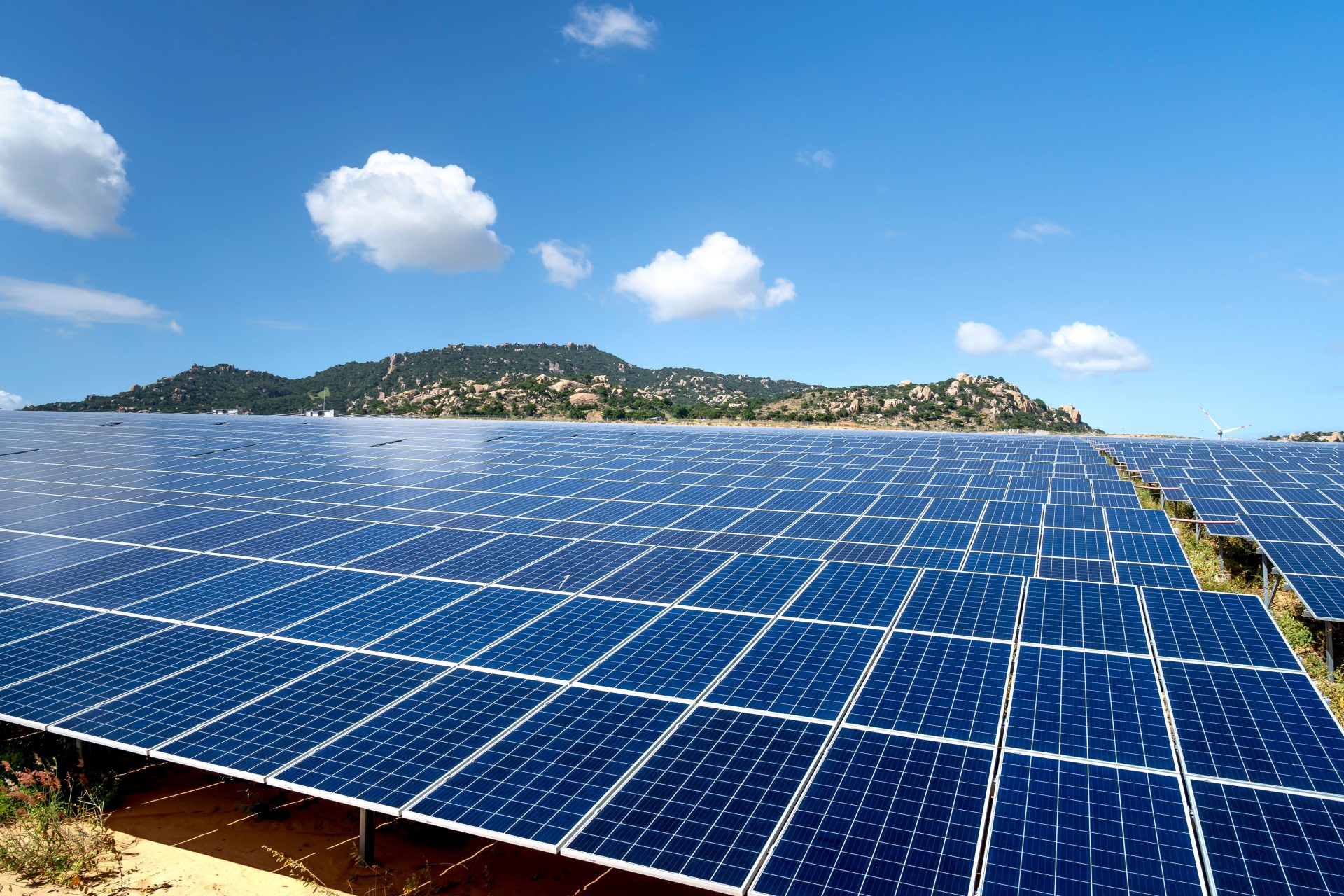 Ein weitläufiger Solarpark mit blauen Solarmodulen unter einem leuchtenden Himmel – ein Sinnbild für erneuerbare Energien.